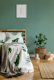 Twin bell alarm clock on a bedside table in a green bedroom